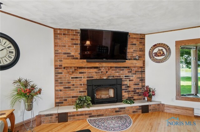 1482 Township Road 55, Ada, OH 45810 - living room with ornamental molding, hardwood / wood-style floors, and a brick fireplace