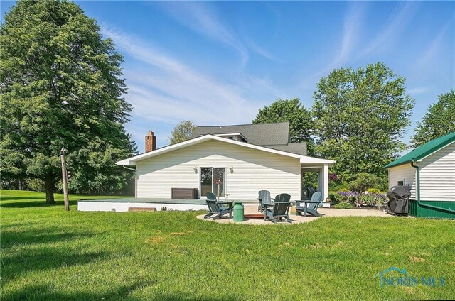 1482 Township Road 55, Ada, OH 45810 - rear view of house featuring a patio area, a yard, and a chimney