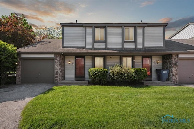 2540 Plum Leaf Ln, Toledo, OH 43614 - view of front of property featuring stone siding, a garage, driveway, and a lawn