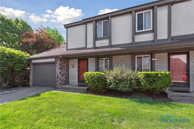 2540 Plum Leaf Ln, Toledo, OH 43614 - view of property featuring driveway, a front yard, a garage, and stone siding