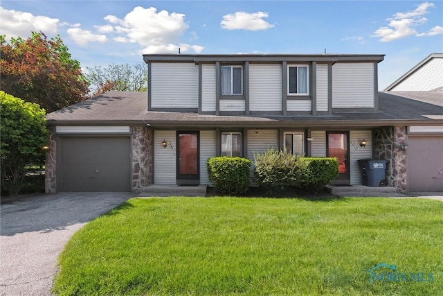 2540 Plum Leaf Ln, Toledo, OH 43614 - view of front of home with a garage, asphalt driveway, stone siding, a front yard, and a shingled roof