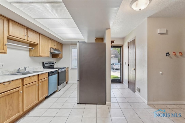 2540 Plum Leaf Ln, Toledo, OH 43614 - kitchen with appliances with stainless steel finishes, under cabinet range hood, a sink, light countertops, and light tile patterned flooring