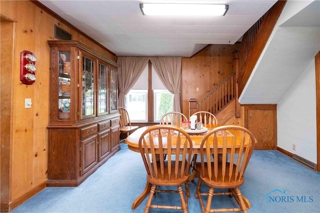 344 E Findlay St, Sugar Creek Township, OH 45893 - dining area featuring wooden walls, light colored carpet, baseboards, and stairs