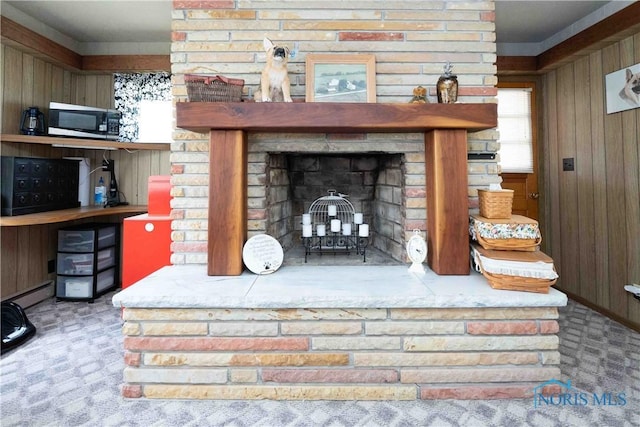344 E Findlay St, Sugar Creek Township, OH 45893 - detailed view of stainless steel microwave, wood walls, a brick fireplace, and carpet flooring