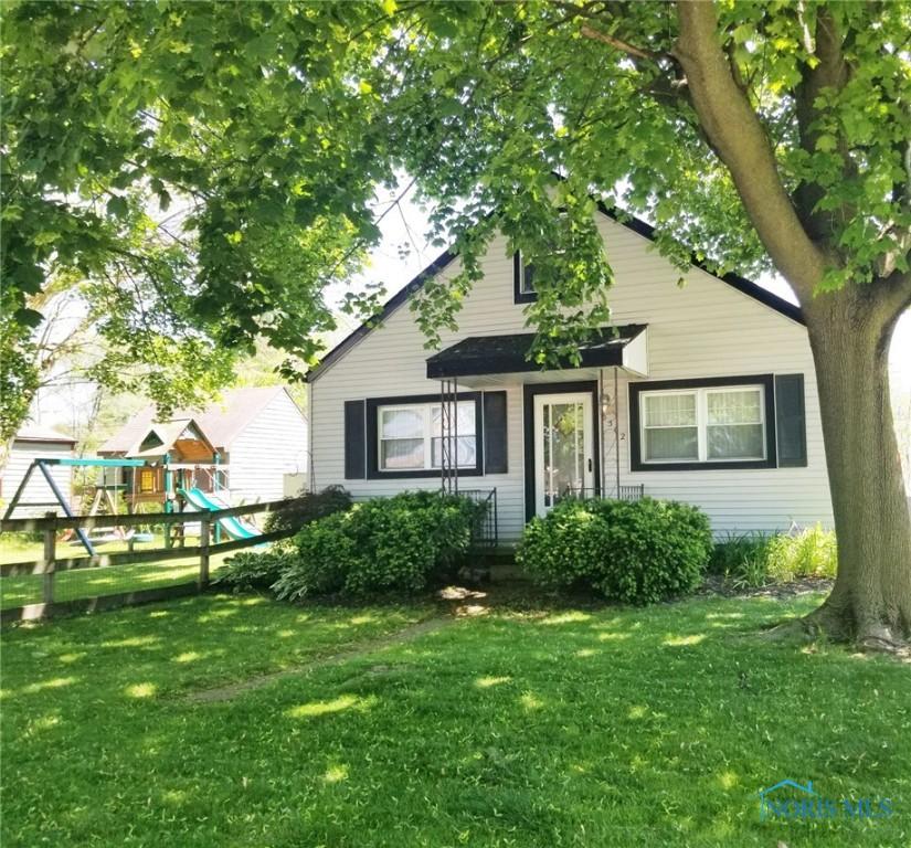 bungalow-style home featuring a playground and a front lawn