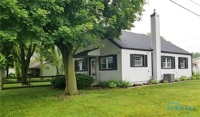 5502 Rudyard Rd, Sylvania, OH 43560 - view of home's exterior featuring a chimney, a yard, roof with shingles, and central AC unit