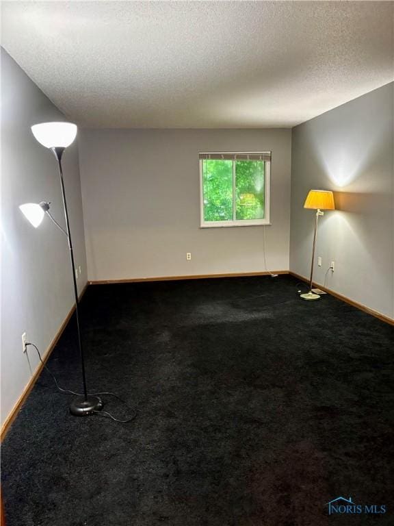 6955 Dorr St Unit 56, Toledo, OH 43615 - unfurnished room featuring baseboards, a textured ceiling, and dark colored carpet