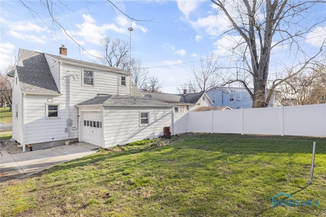 259 W Elm St, Wauseon, OH 43567 - rear view of property featuring a shingled roof, an attached garage, a chimney, and concrete driveway