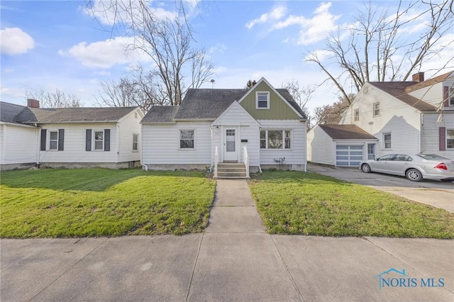 259 W Elm St, Wauseon, OH 43567 - view of front of home featuring board and batten siding, a front yard, an outdoor structure, and driveway