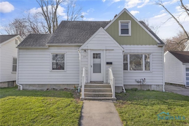 259 W Elm St, Wauseon, OH 43567 - bungalow-style house with a front yard, board and batten siding, and roof with shingles
