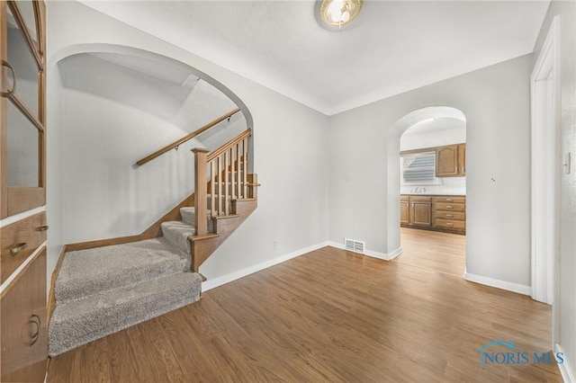 259 W Elm St, Wauseon, OH 43567 - foyer entrance featuring arched walkways, wood finished floors, stairs, and baseboards