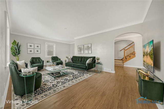 259 W Elm St, Wauseon, OH 43567 - living area with arched walkways, baseboards, crown molding, wood finished floors, and stairs