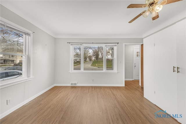 259 W Elm St, Wauseon, OH 43567 - empty room featuring wood finished floors, plenty of natural light, and baseboards