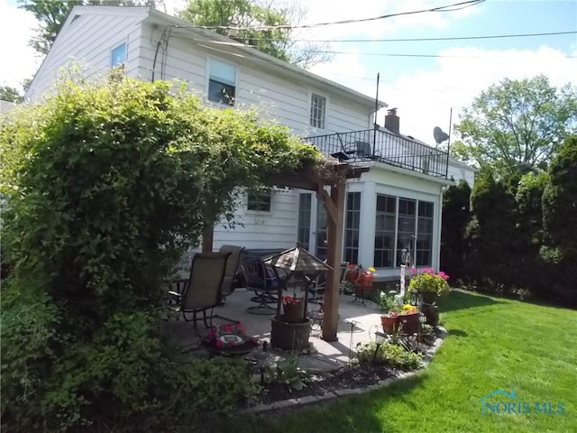 3440 Mapleway Dr, Toledo, OH 43614 - rear view of property featuring a balcony, a patio, a lawn, and a chimney