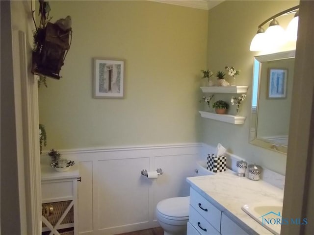 3440 Mapleway Dr, Toledo, OH 43614 - half bathroom with wainscoting, toilet, a decorative wall, vanity, and ornamental molding
