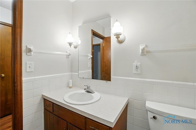 1110 Bourgogne Ave, Bowling Green, OH 43402 - half bath with vanity, tile walls, a wainscoted wall, and toilet