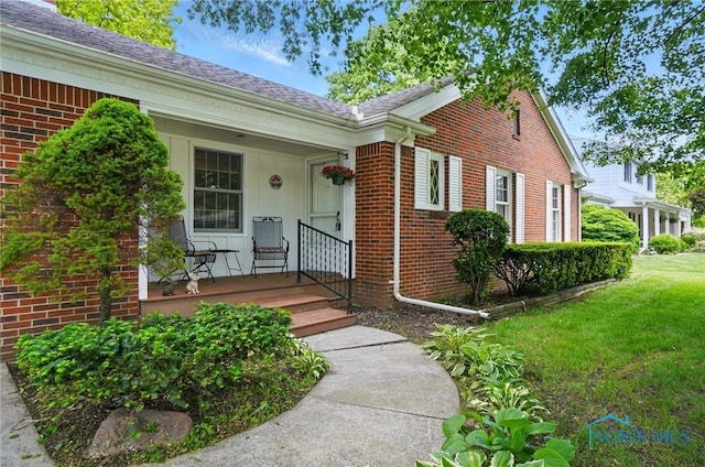 1110 Bourgogne Ave, Bowling Green, OH 43402 - property entrance featuring a porch, brick siding, a lawn, and a shingled roof