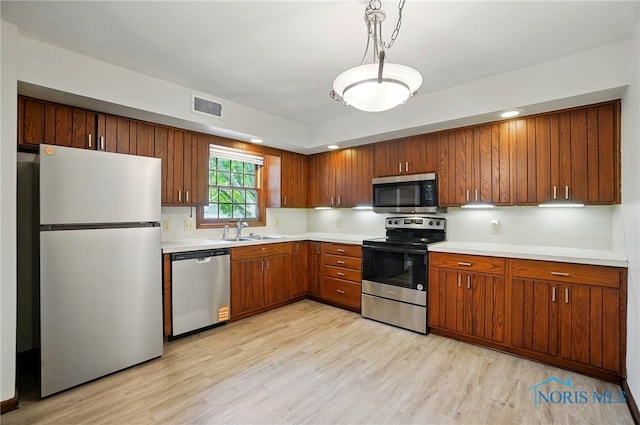 1110 Bourgogne Ave, Bowling Green, OH 43402 - kitchen with appliances with stainless steel finishes, a sink, light wood-type flooring, and light countertops