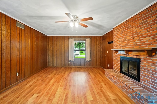 1110 Bourgogne Ave, Bowling Green, OH 43402 - unfurnished living room with wood finished floors, a ceiling fan, a brick fireplace, crown molding, and wooden walls