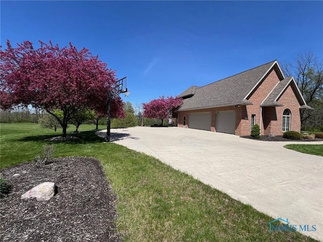5506 Brookview Ln, Upper Sandusky, OH 43351 - view of property exterior featuring brick siding, a garage, a yard, and driveway