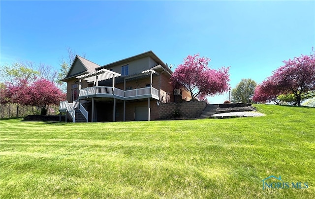 5506 Brookview Ln, Upper Sandusky, OH 43351 - rear view of property featuring stairs, a wooden deck, a yard, a garage, and brick siding