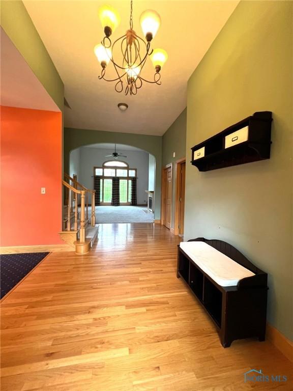 5506 Brookview Ln, Upper Sandusky, OH 43351 - hall with arched walkways, light wood-style floors, and a chandelier