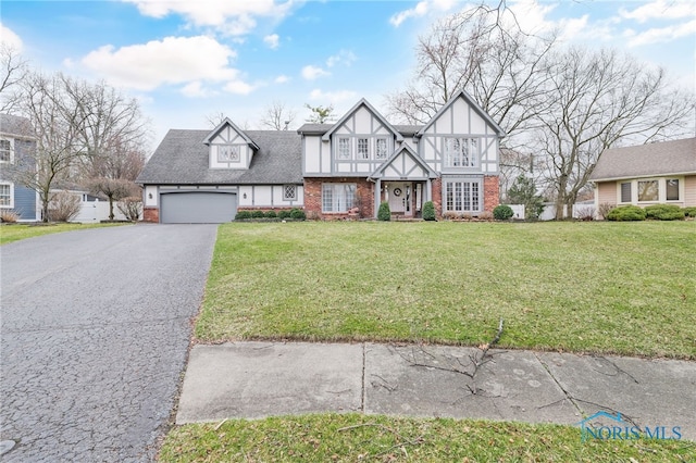 521 Erie Ct, Bowling Green, OH 43402 - tudor-style house featuring brick siding, asphalt driveway, and a front yard