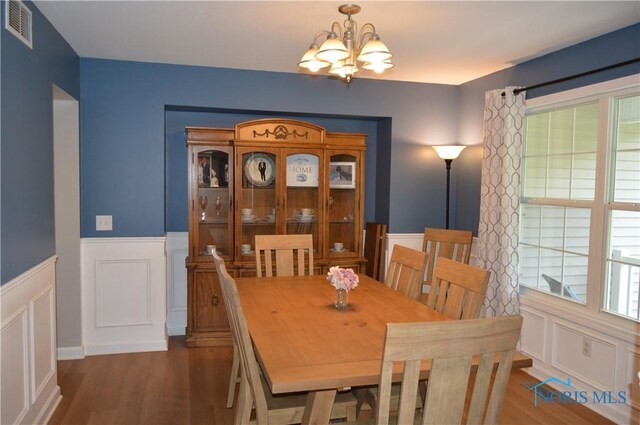 1243 1st St, Findlay, OH 45840 - dining area featuring a chandelier, a wainscoted wall, dark wood-type flooring, and a decorative wall
