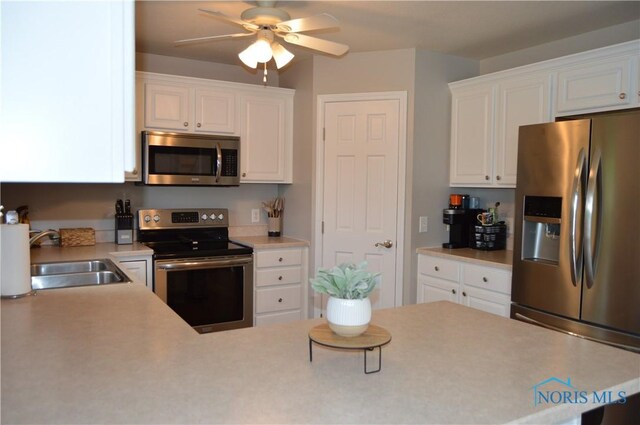 1243 1st St, Findlay, OH 45840 - kitchen with stainless steel appliances, a sink, white cabinetry, ceiling fan, and light countertops