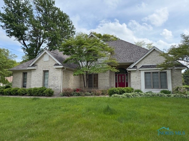8411 Willow Glen Ct, Holland, OH 43528 - view of front of house featuring brick siding, a front yard, and roof with shingles