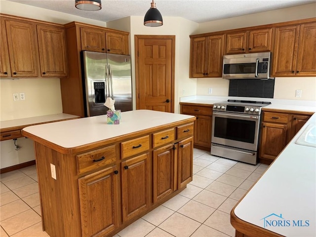 8411 Willow Glen Ct, Holland, OH 43528 - kitchen with stainless steel appliances, light tile patterned floors, brown cabinetry, light countertops, and a kitchen island