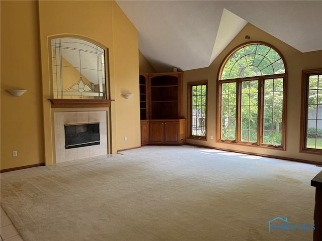 8411 Willow Glen Ct, Holland, OH 43528 - unfurnished living room featuring carpet flooring, plenty of natural light, a tile fireplace, and vaulted ceiling