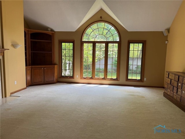 8411 Willow Glen Ct, Holland, OH 43528 - unfurnished living room featuring light colored carpet and lofted ceiling