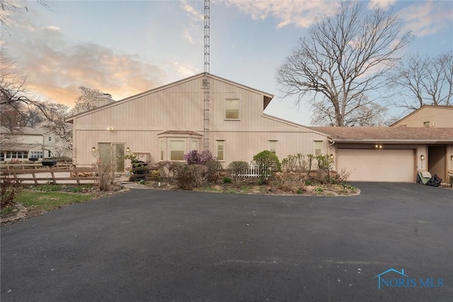 2439 Parliament Sq Unit 2439, Toledo, OH 43617 - view of front of house with asphalt driveway, an attached garage, fence, and a chimney