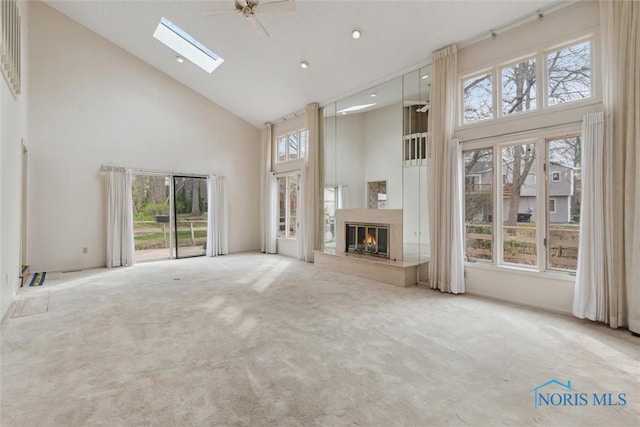 2439 Parliament Sq Unit 2439, Toledo, OH 43617 - unfurnished living room with high vaulted ceiling, carpet, a glass covered fireplace, recessed lighting, and a skylight