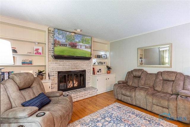 4911 Claradale Rd, Toledo, OH 43614 - living room with wood finished floors, a fireplace, ornamental molding, built in shelves, and a textured ceiling