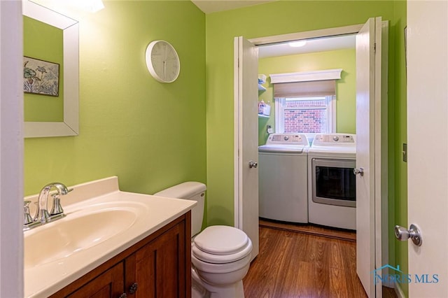 4911 Claradale Rd, Toledo, OH 43614 - half bath with washing machine and clothes dryer, wood finished floors, toilet, and vanity