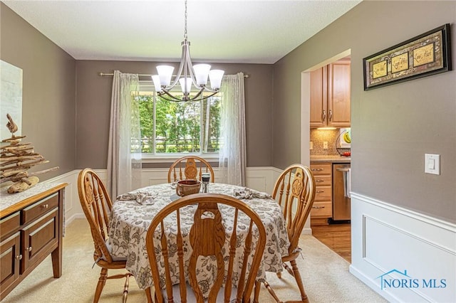 4911 Claradale Rd, Toledo, OH 43614 - dining space with a chandelier, a wainscoted wall, and light colored carpet