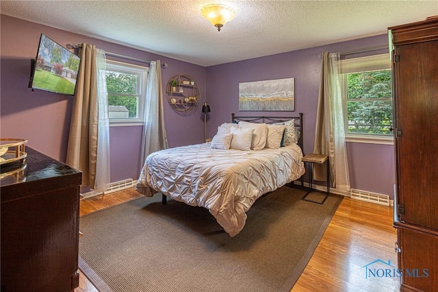 4911 Claradale Rd, Toledo, OH 43614 - bedroom featuring light wood-style floors, a textured ceiling, and baseboards