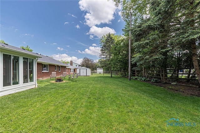 4911 Claradale Rd, Toledo, OH 43614 - view of yard featuring a storage shed, a fire pit, and an outdoor structure