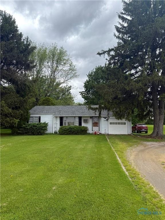 1110 Sandusky St, Fostoria, OH 44830 - view of front facade with driveway, a front lawn, and a garage