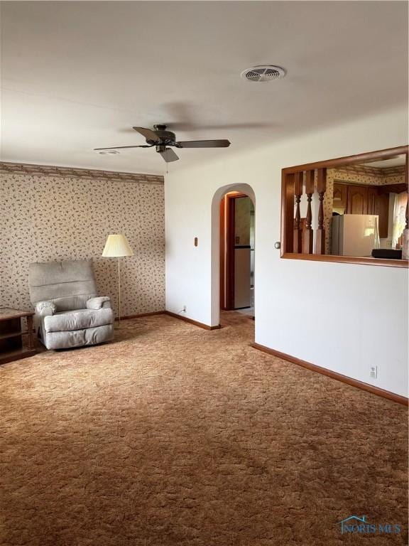 1110 Sandusky St, Fostoria, OH 44830 - unfurnished living room with arched walkways, carpet flooring, ceiling fan, and baseboards