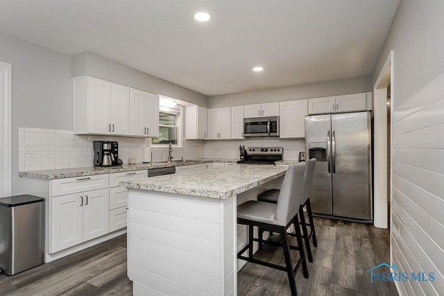 510 N Wintergarden Rd, Bowling Green, OH 43402 - kitchen with appliances with stainless steel finishes, dark wood finished floors, white cabinets, a center island, and recessed lighting