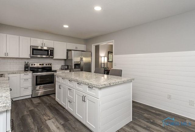 510 N Wintergarden Rd, Bowling Green, OH 43402 - kitchen featuring appliances with stainless steel finishes, dark wood-type flooring, white cabinets, light stone counters, and backsplash