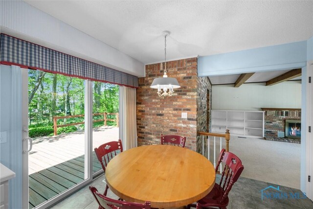 806 Woodstock Ct, Findlay, OH 45840 - tiled dining space with a chandelier, a brick fireplace, and a textured ceiling