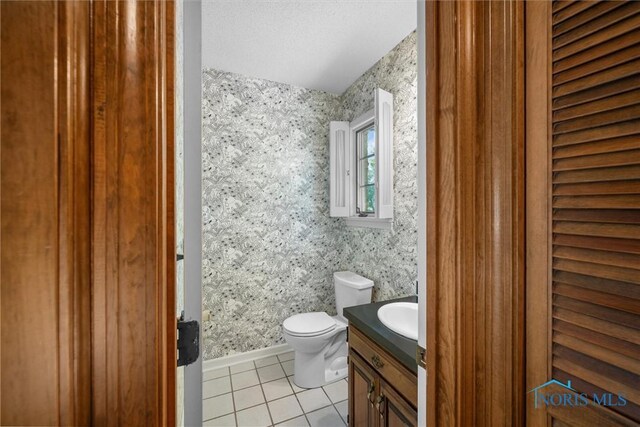 806 Woodstock Ct, Findlay, OH 45840 - bathroom featuring tile patterned floors, toilet, vanity, and wallpapered walls