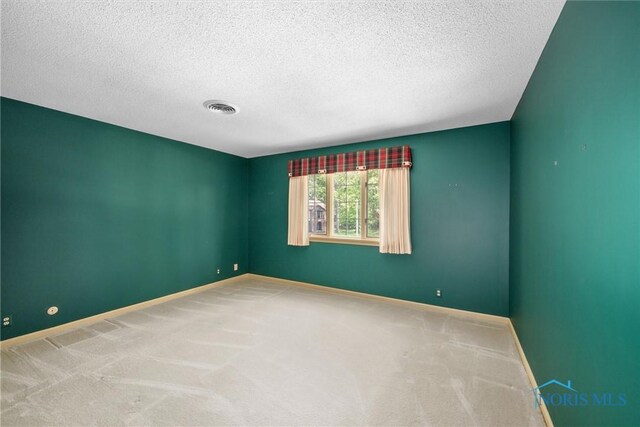 806 Woodstock Ct, Findlay, OH 45840 - spare room with baseboards, a textured ceiling, and carpet flooring