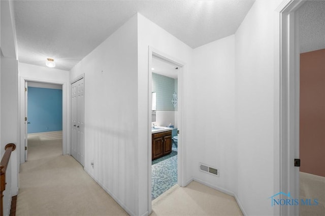 806 Woodstock Ct, Findlay, OH 45840 - hall featuring light carpet, a sink, baseboards, and a textured ceiling