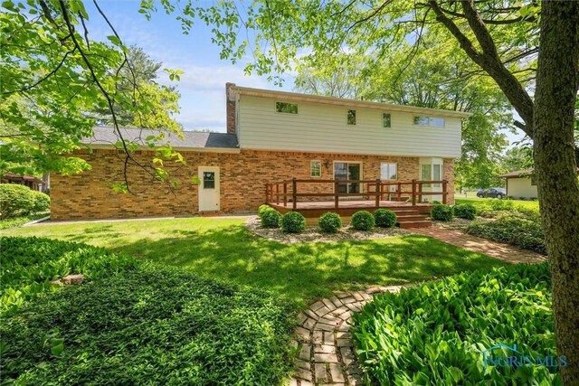 806 Woodstock Ct, Findlay, OH 45840 - rear view of property featuring a wooden deck, brick siding, and a lawn