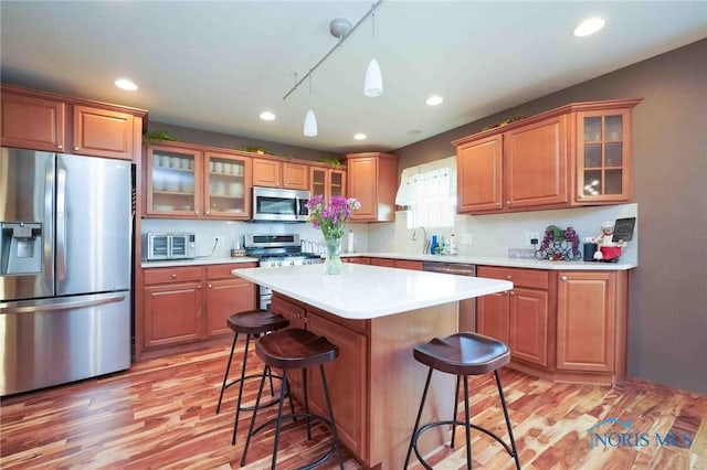 501 Flintlock Ct, Findlay, OH 45840 - kitchen with stainless steel appliances, a breakfast bar, light wood-style flooring, light countertops, and recessed lighting